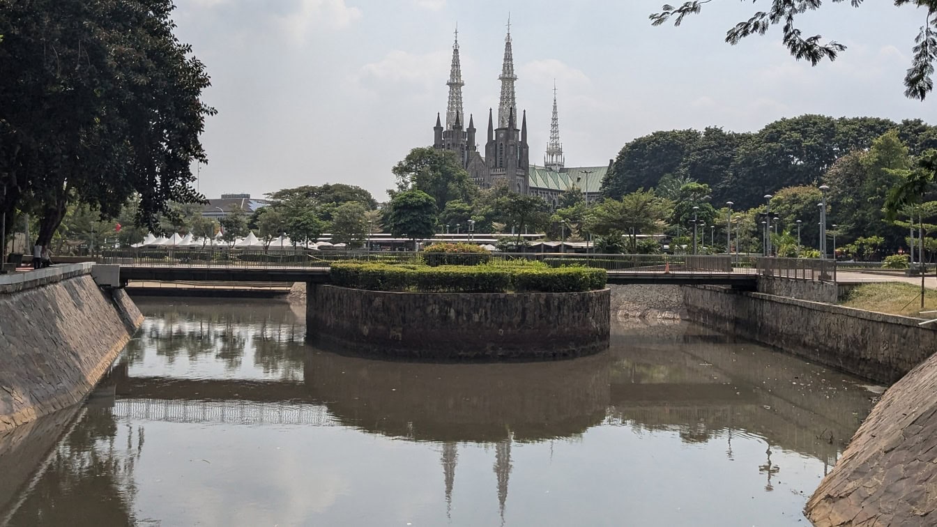 Endonezya, Jakarta’da arka planda bir Roma Katolik katedrali ile güzel bir bahçe