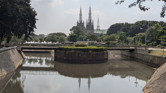 Vakker hage med en romersk-katolsk katedral i bakgrunnen i Jakarta, Indonesia