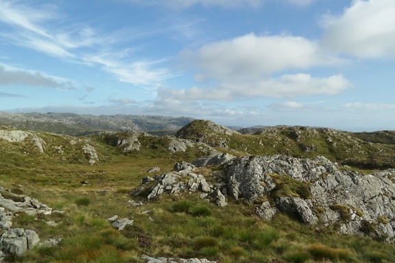 Kaunis panoraama pohjoismaisille vuorille, jossa on nurmialue kukkuloiden huipuilla