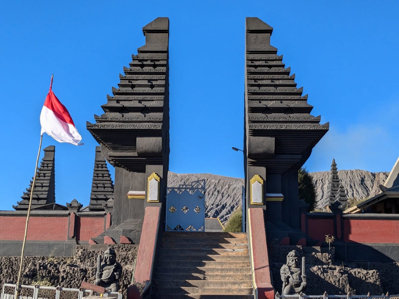 Et flagg fra Indonesia vaier i luften ved porten til Bromo-tempelet, et hinduistisk tempel på Java, Indonesia