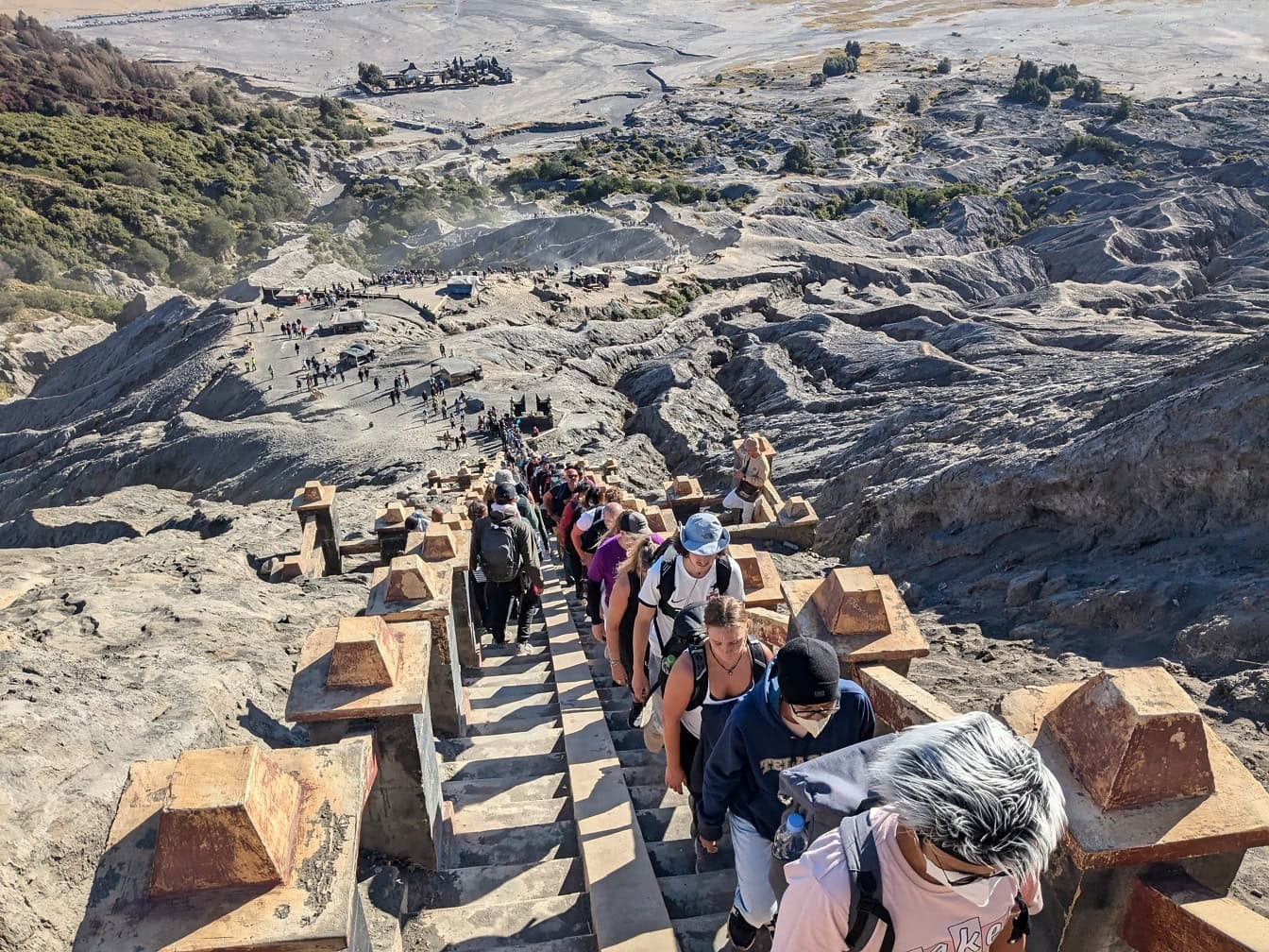 A crowd of people climbing a staircase up a mountain at a famous tourist attraction on mountain Bromo, Indonesia