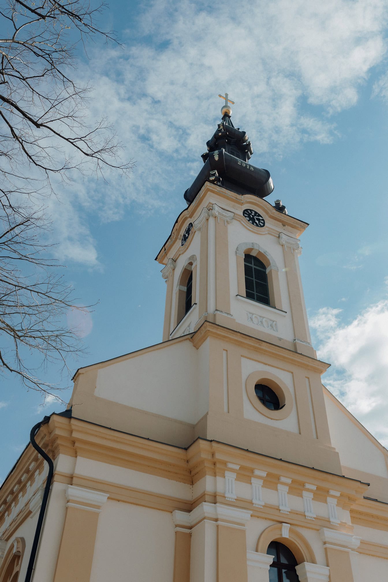 Uma torre sineira da igreja de São Lucas com uma cruz dourada no topo, uma igreja ortodoxa na Sérvia