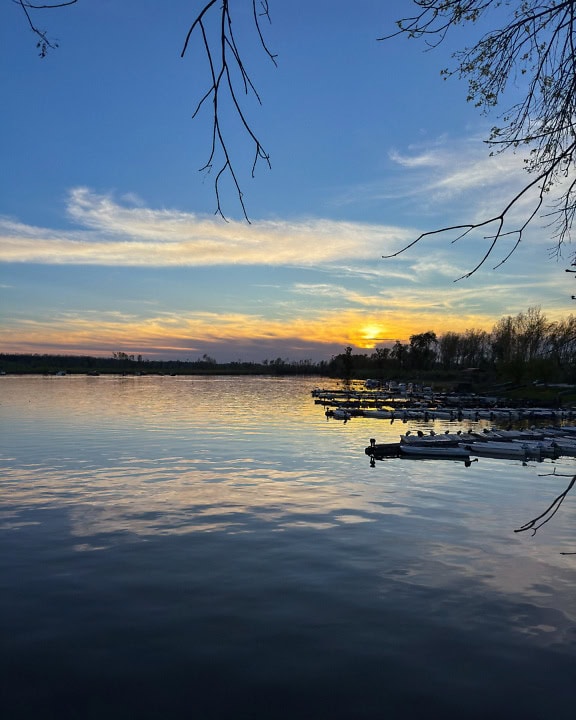 Majesteettinen järvenranta auringonnousun aikaan pienillä kalastusveneillä Tikvara-järvellä, Bačka Palanka, Serbia