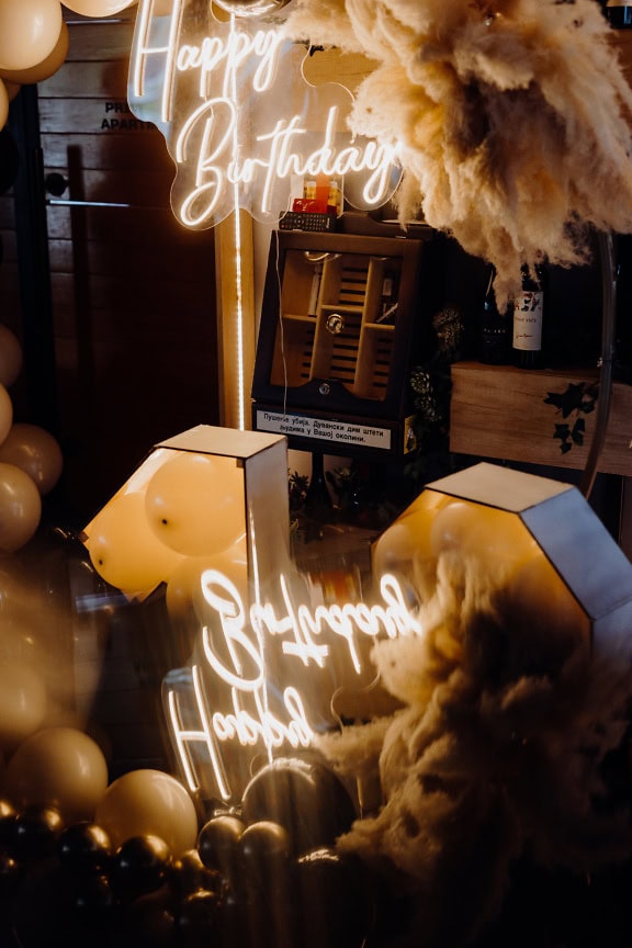 Reflection of white neon lights with an inscription of Happy Birthday at birthday party