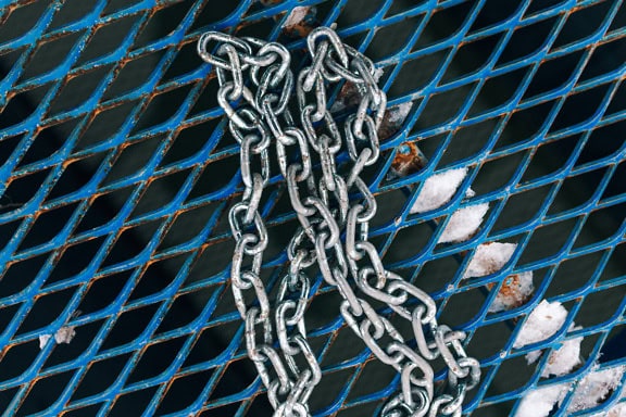 A galvanized steel chain on a blue metal grate