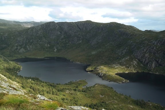 Beautiful lake surrounded by green mountains in natural park, Norway