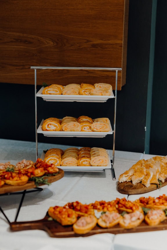 Dienbladen met heerlijke kaasbroodjes, zelfgemaakte broodjes en ander eten voor een ontbijt