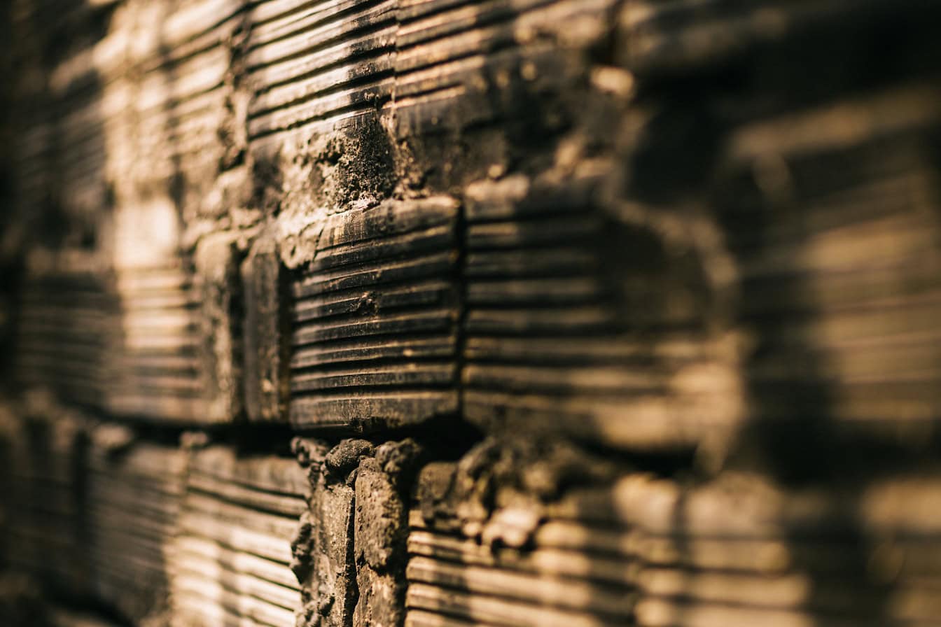 Texture of an old dirty wall made of clay blocks in shadow