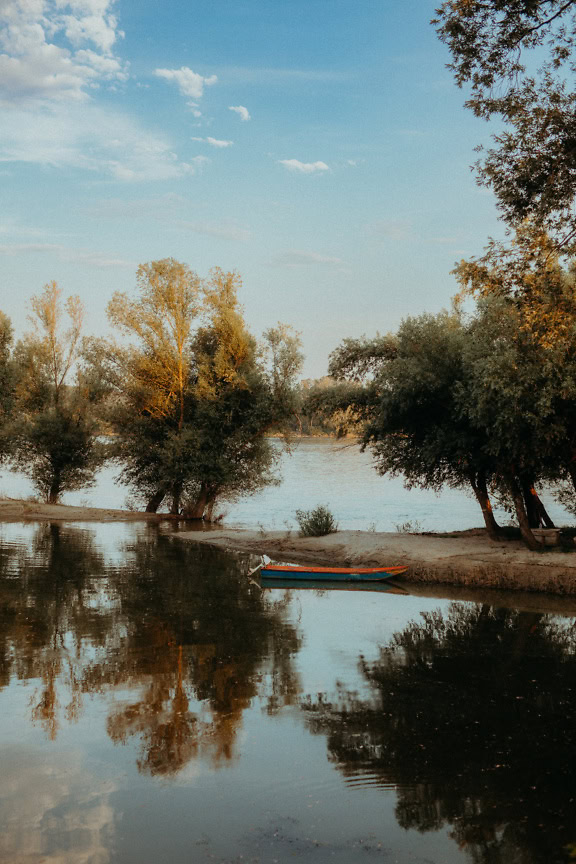 A small fishing motor boat on the sandbar of the Danube bank