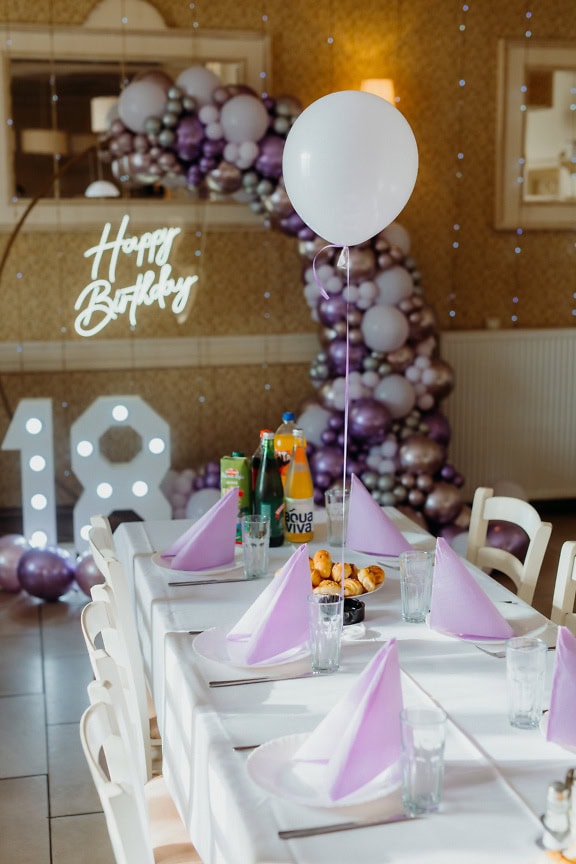 Table set for birthday party with white balloon on it