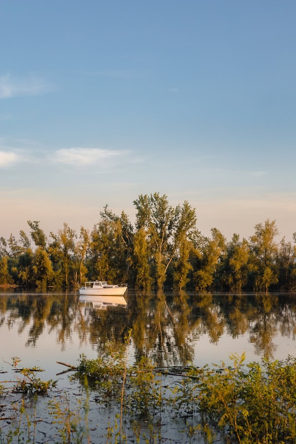 Malá rybárska loď na pokojnej vode jazera