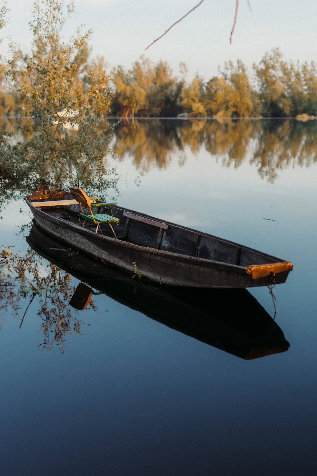 Barco de pesca de madeira com cadeira nele no lago