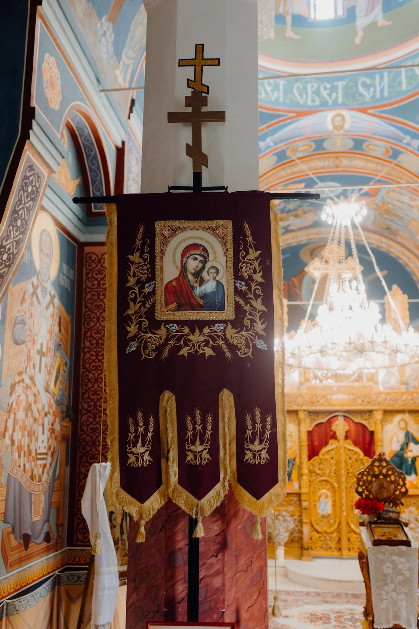 Banderoll med en bild av Jungfru Maria, Jesu Kristi moder från Nasaret på en pelare med kors på den i en serbisk-ortodox kyrka