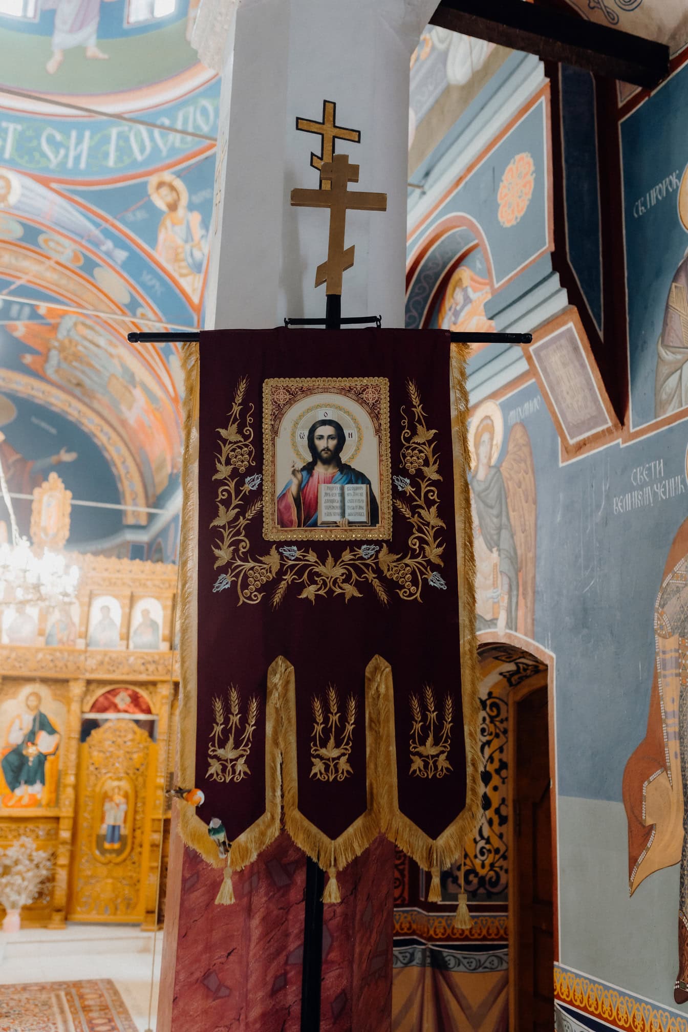 Bandeira religiosa com uma imagem de Jesus Cristo de Nazaré pendurada em um pilar com cruz em uma igreja ortodoxa