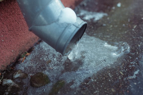 Tuyau de vidange de gouttière avec de la glace gelée solide dessus