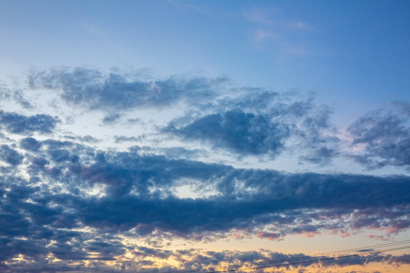 Mörkblå moln på den blåaktiga himlen i skymningen