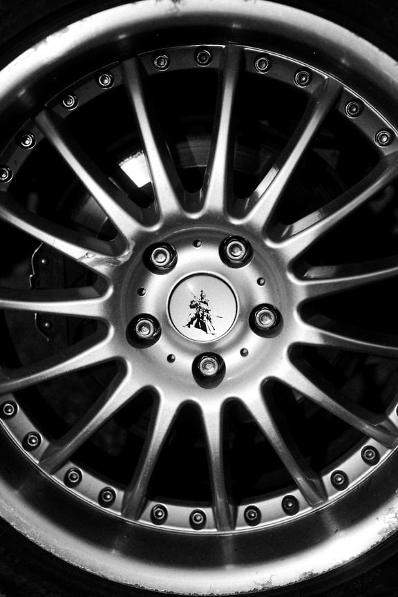 Shining aluminum car wheel with a sign of a samurai, a close-up black and white photograph