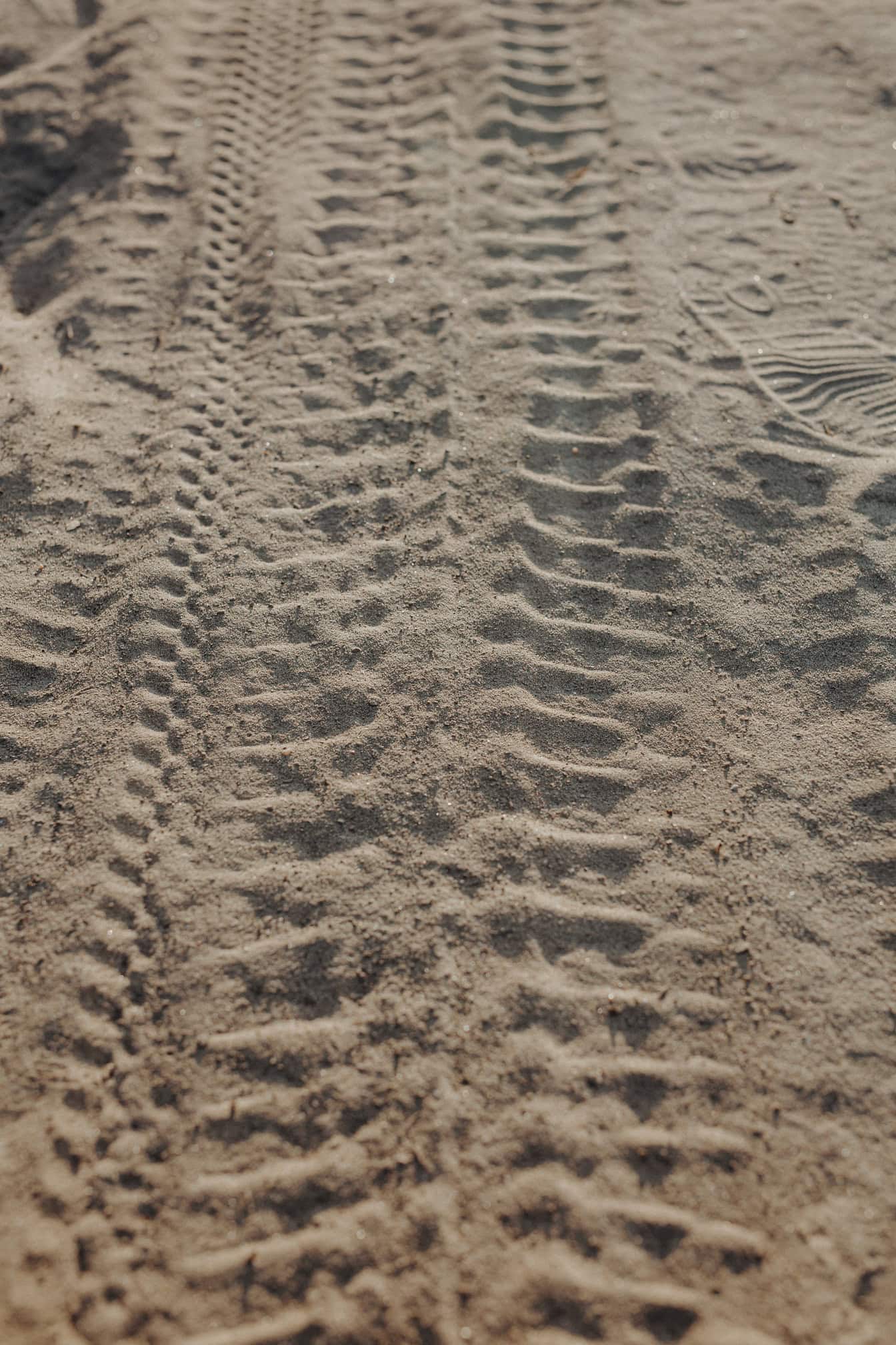 Traces de pneus dans le sable sec sur un chemin de terre