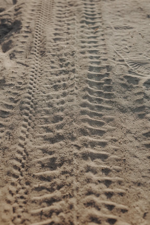 Tire tracks in the dry sand on dirtroad