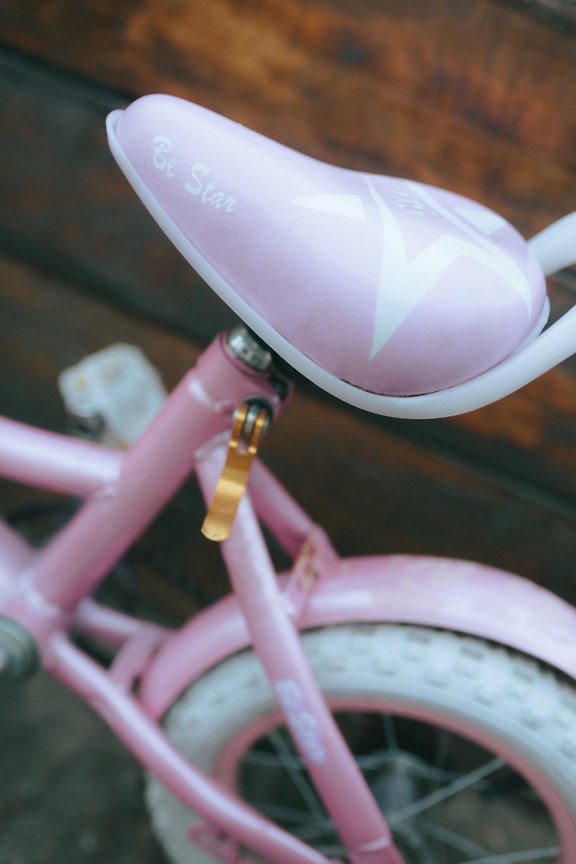 Liten rosa cykel med vita hjul med fokus på rosa säte