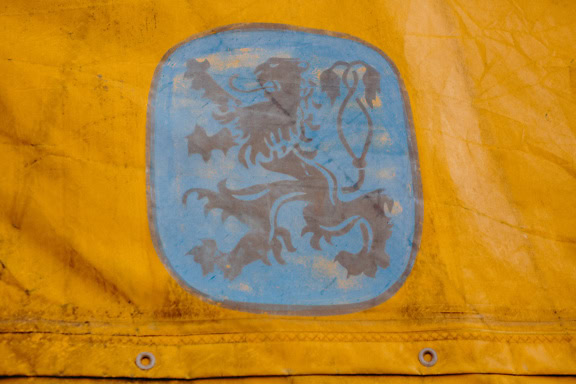 A heraldic symbol of lion on yellow tarp, a blue sign similar to medieval coat of arms with a lion with a yellow background