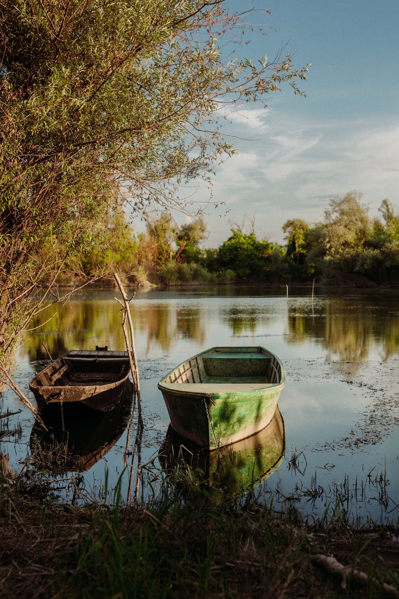 Două bărci vechi de pescuit pe malul unui lac