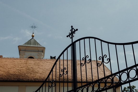 Cast iron gate with an Orthodox cross on top, an entrance to Divsa (đipša) a monastery in a diocese of Srem of the Serbian Orthodox church