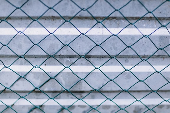 Texture d’une clôture en fil de fer vert foncé avec une surface en métal galvanisé avec des lignes horizontales comme arrière-plan