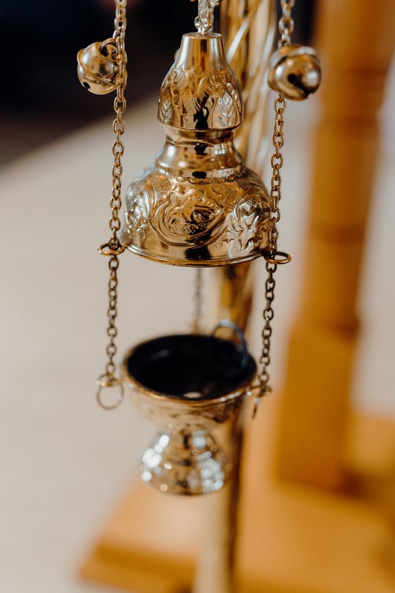 A shining brass ecclesiastical censer in Christian church used in a religious liturgy