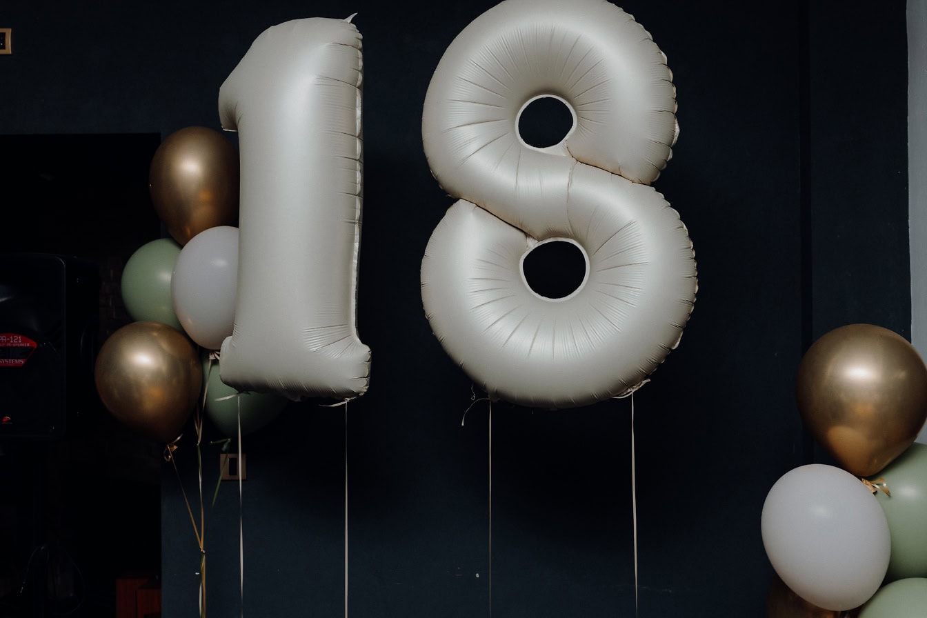 Une fête d’anniversaire avec des ballons à l’hélium en forme de dix-huit (18)