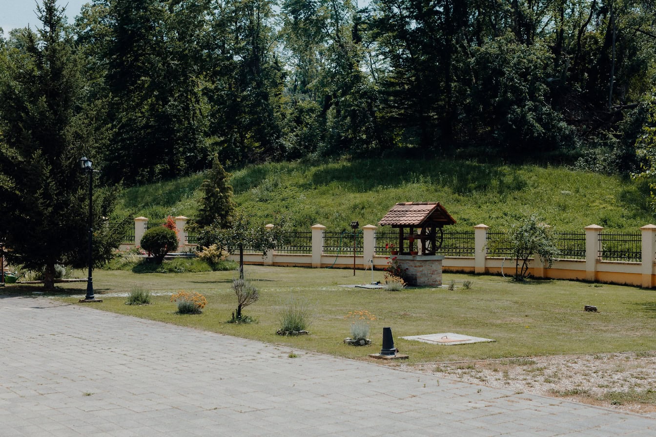 Ein Brunnen in einem hübschen Hinterhof mit Rasen