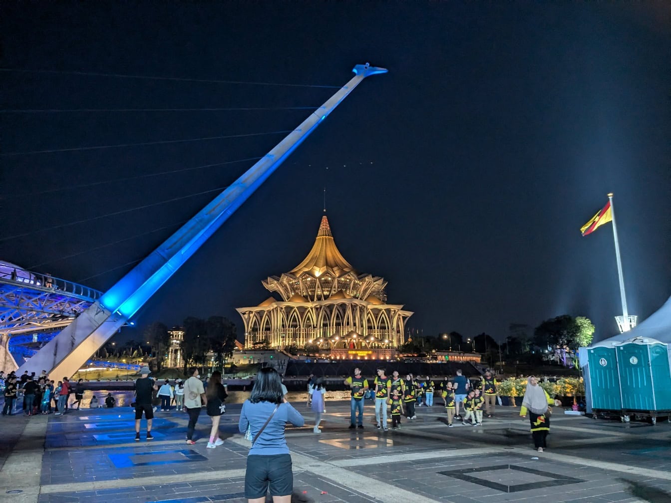 Mensen voor een gebouw van de Wetgevende Vergadering van de Staat Sarawak ‘s nachts in Kuching, Maleisië