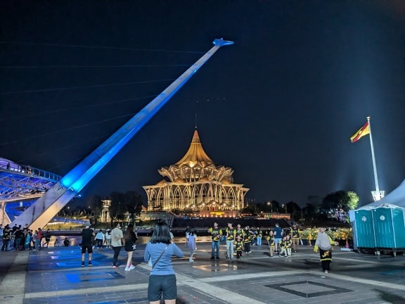 Människor framför en byggnad för Sarawaks lagstiftande församling på natten i Kuching, Malaysia