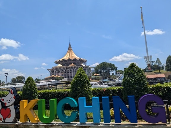 Schild mit Text Kuching vor einem Gebäude der Legislativversammlung des Bundesstaates Sarawak in Malaysia