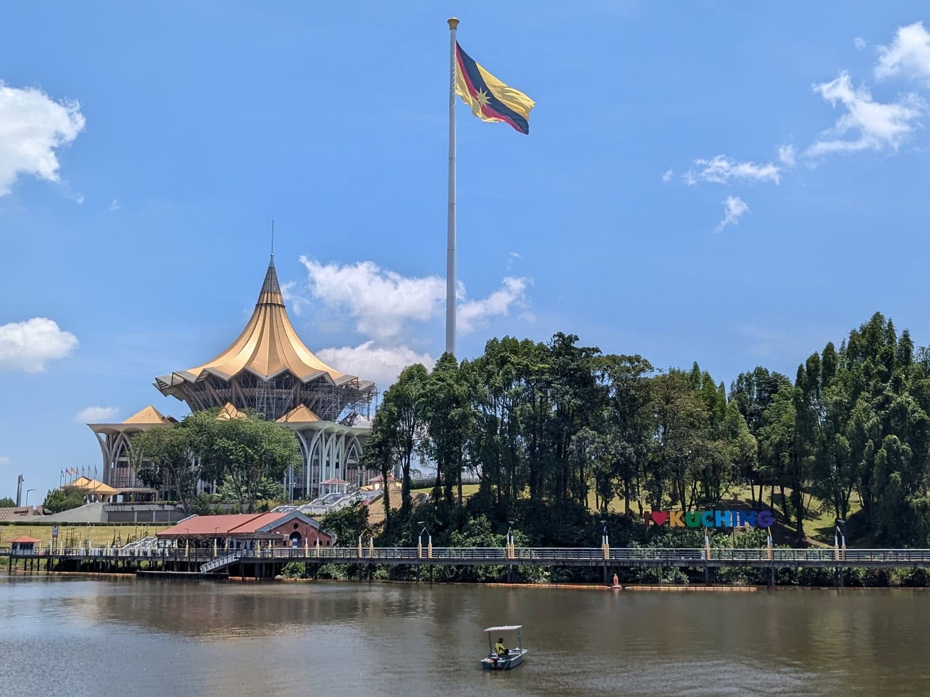 Edificio de la Asamblea Legislativa del Estado de Sarawak con una bandera de Sarawak en la parte superior de un mástil, atracciones turísticas populares en Malasia