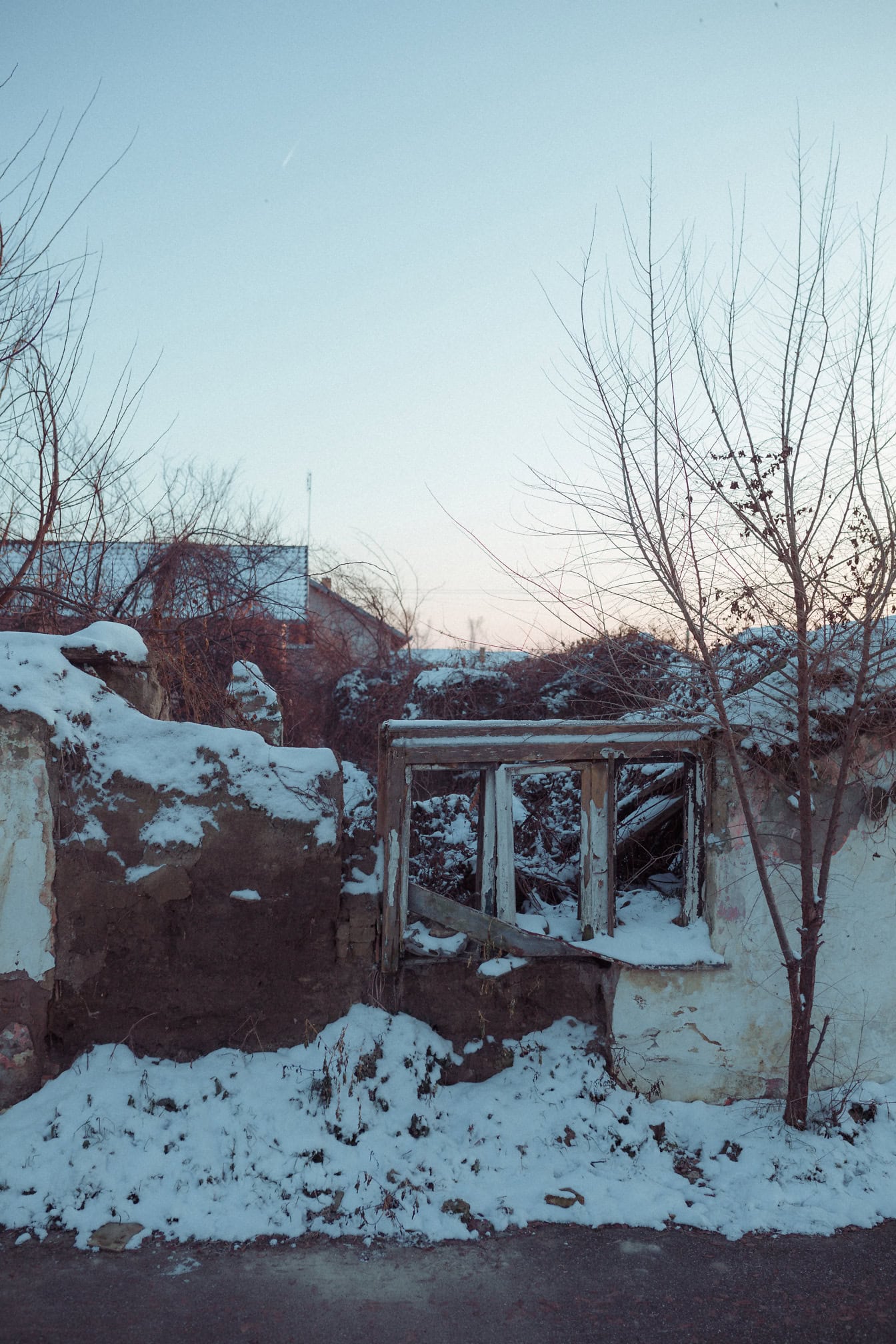 Ein altes, verlassenes und verfallenes Haus ohne Dach und mit eingestürzten Wänden, die mit Schnee bedeckt sind