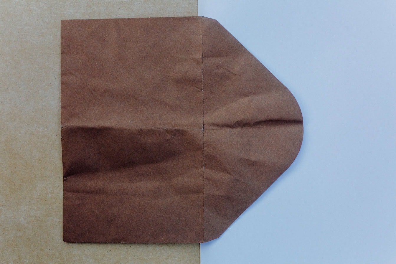 Dark brown envelope on a white and light brown paper surface