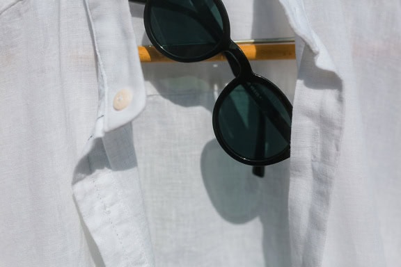 Classic black sunglasses and a white shirt on a ofinger