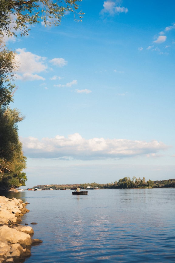 Small fishing boat with fisherman in it on the Danube river