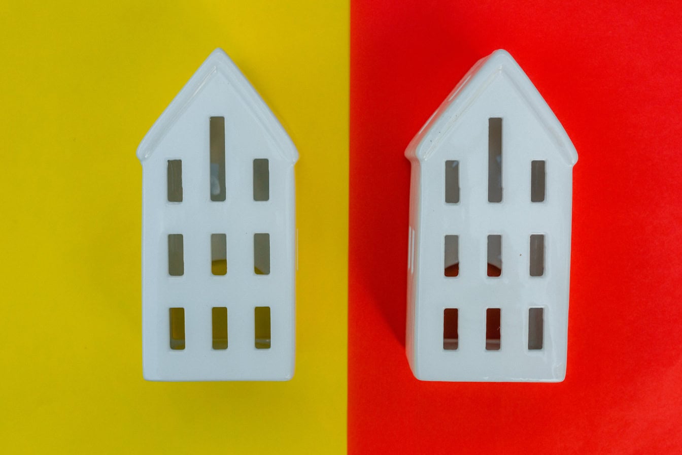 Two white houses on a yellow and red background