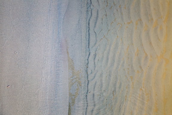 Close-up of a wet sandy surface with an undulating texture underwater