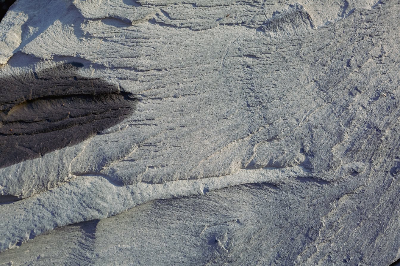 Gros plan d’une roche de grès gris avec une tache d’huile de moteur dessus