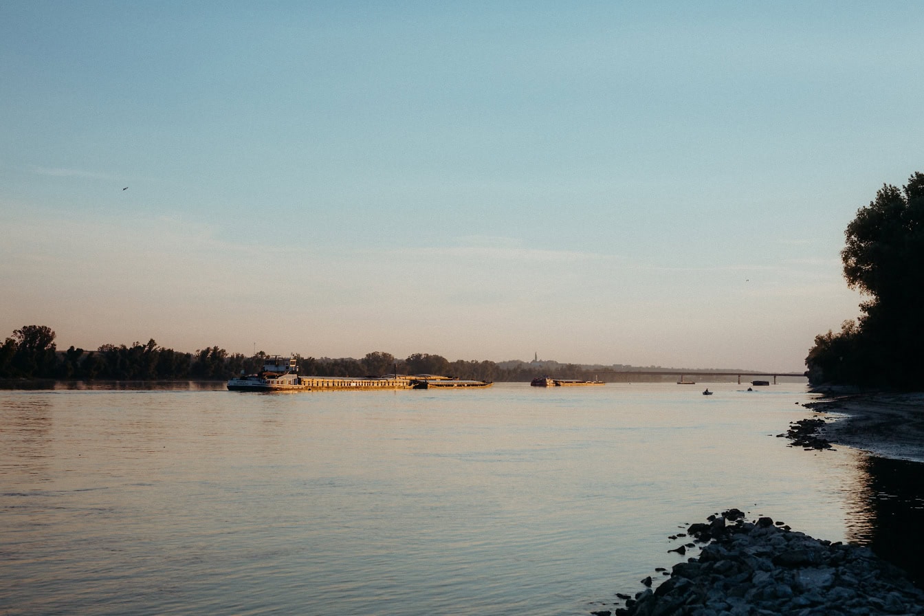 Большая баржа на водном пути Дуная в сумерках