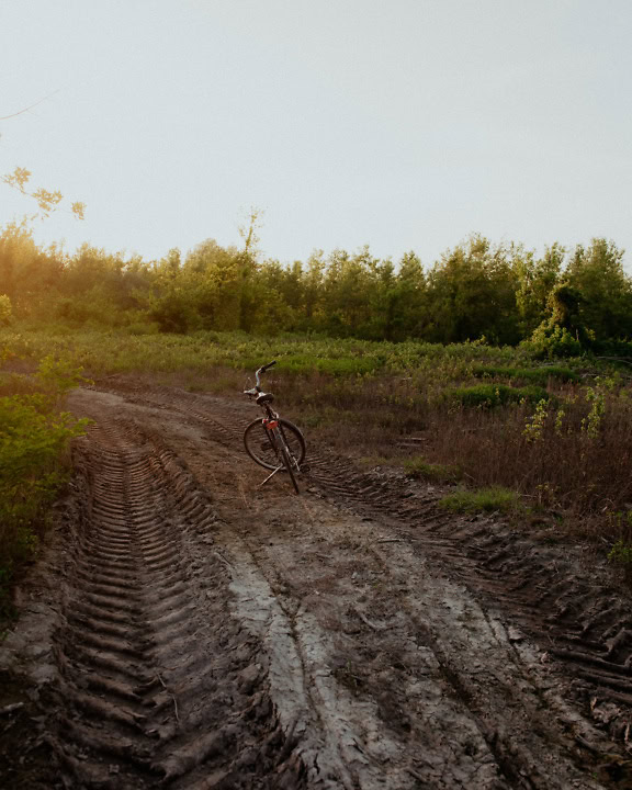 Vélo sur un chemin de terre boueux avec des marques de roues