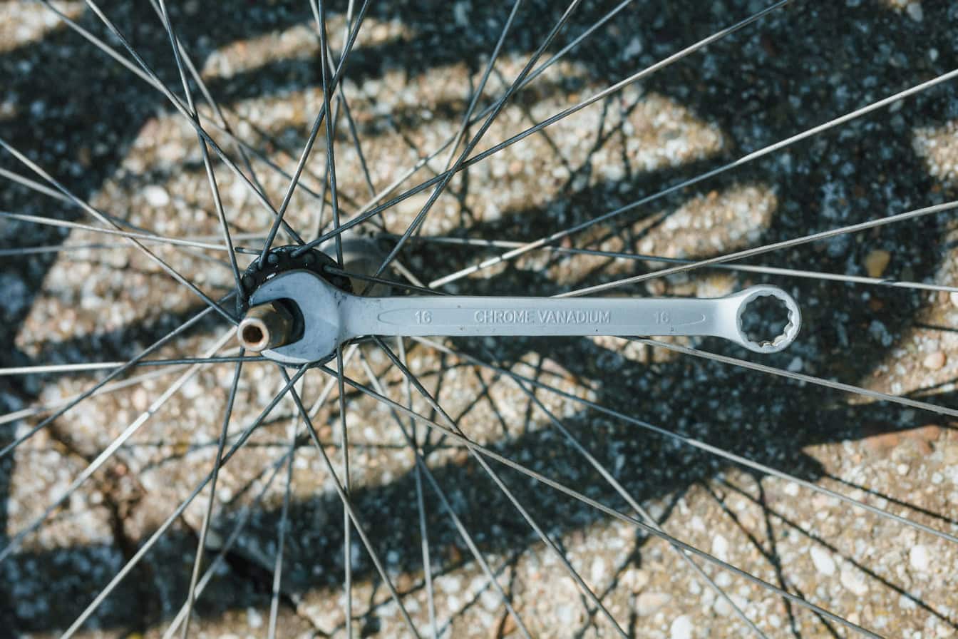 Chave do mecânico do cromo-vanádio em uma porca de aço da roda de bicicleta