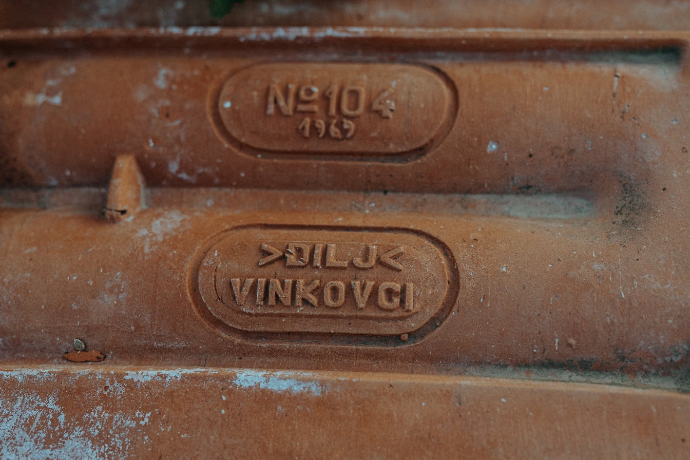 A clay roof tile with markings, the serial number, the numero sign № 104, manufactured date 1969 and with sign of manufacturer