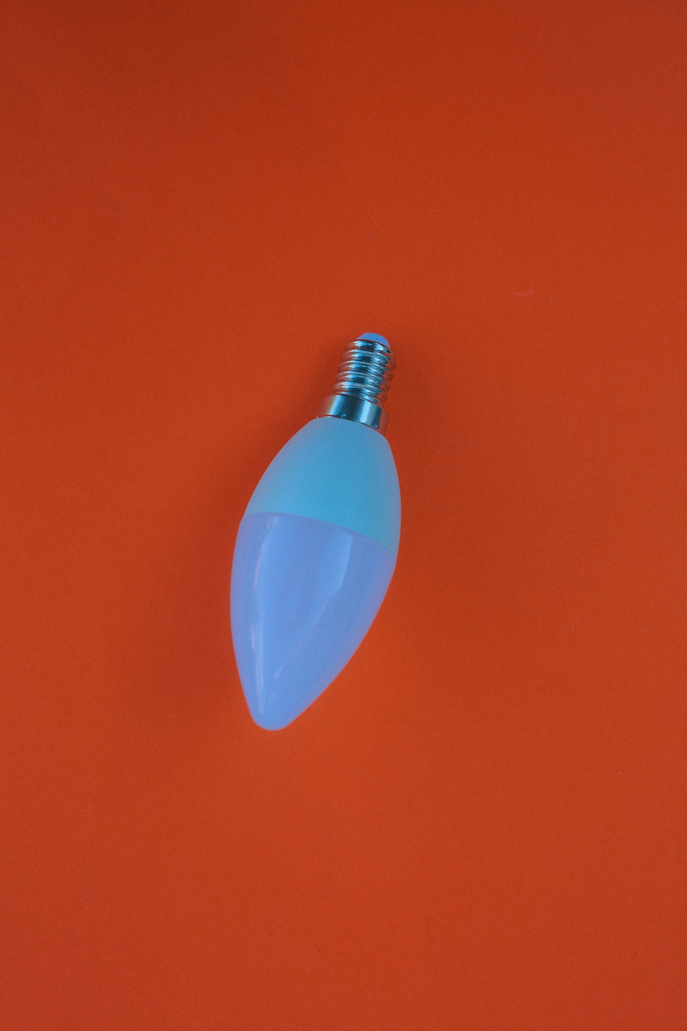 A lightbulb with light emitted diode, an energy-saving LED lightbulb on an orange surface