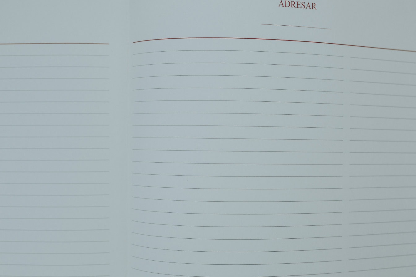 Close-up of an address notebook with blank white pages with horizontal lines