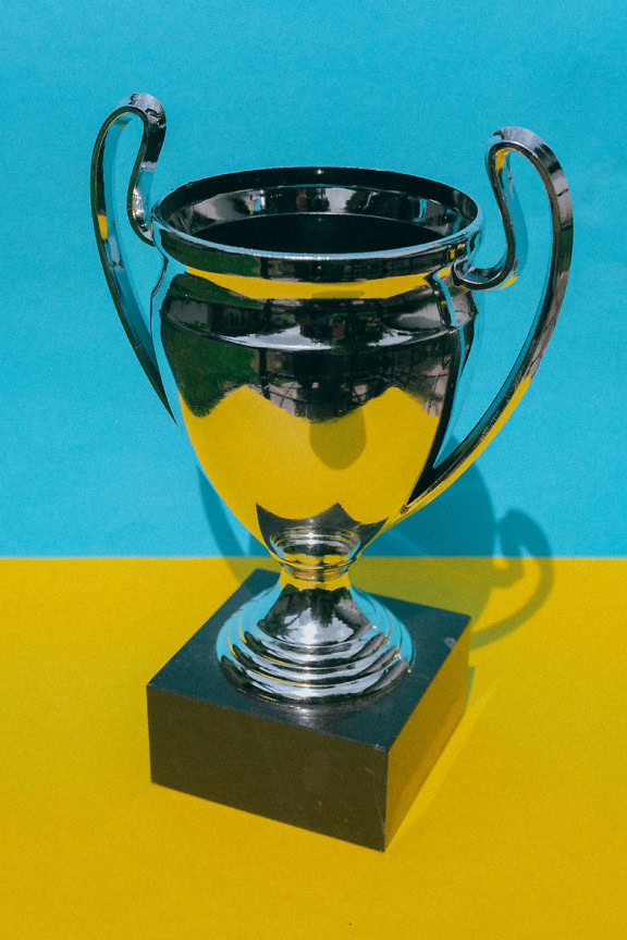 Silver-platinum trophy on a yellow and blue background