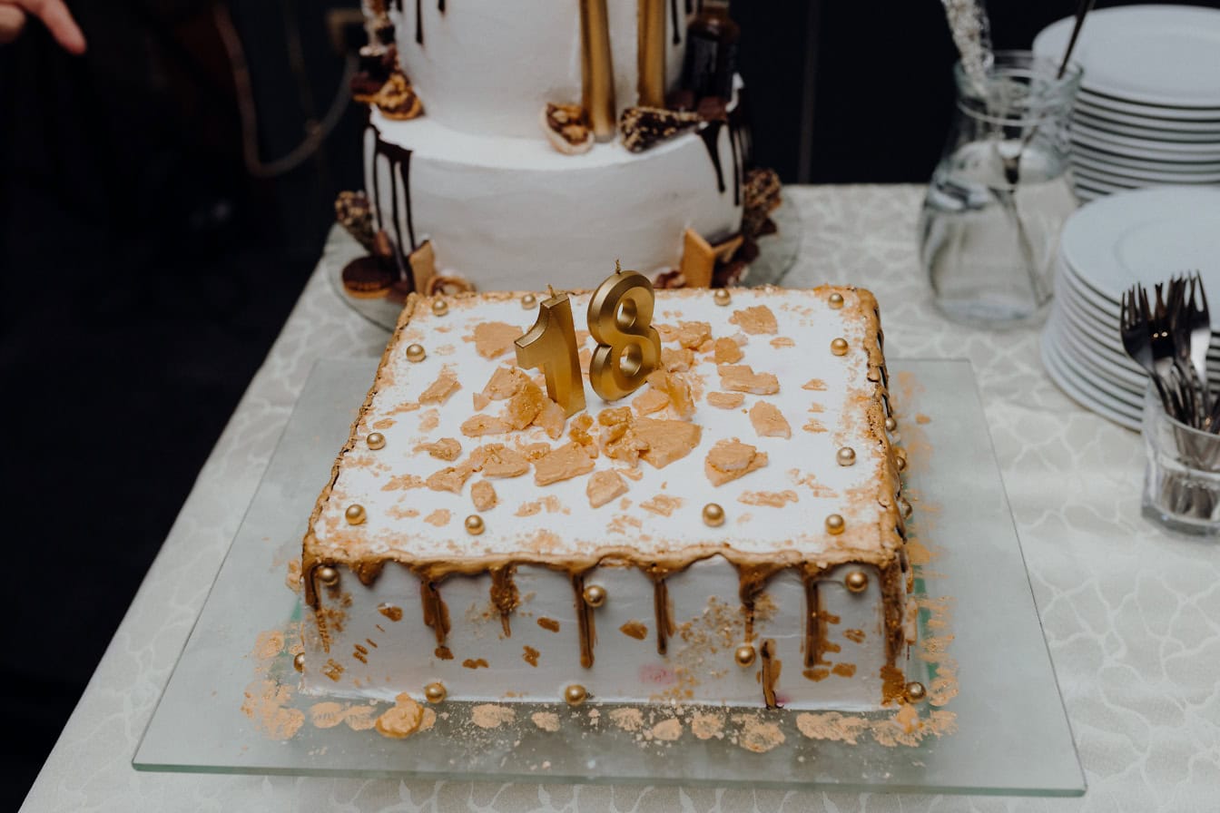 Un gâteau d’anniversaire pour dix-huit ans avec des bougies en forme de numéro 18 dessus